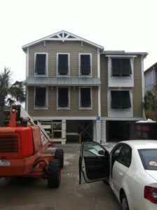 Modern coastal home in Wilmington with dark hurricane shutters.