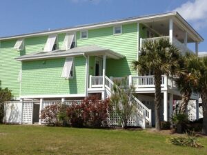 Topsail, NC: Elevated lime green beach house, white shutters, palm.