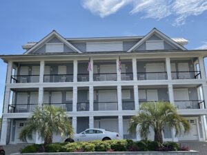 Wilmington luxury coastal home with hurricane shutters and sports car.