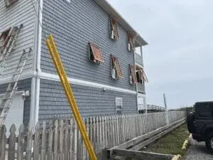 Gray beach house with hurricane shutters and storm panels.