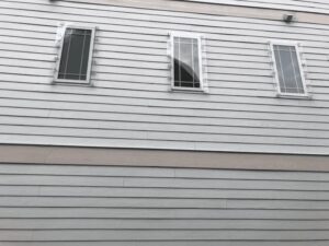 Wilmington NC home: pale siding, three hurricane-rated windows.