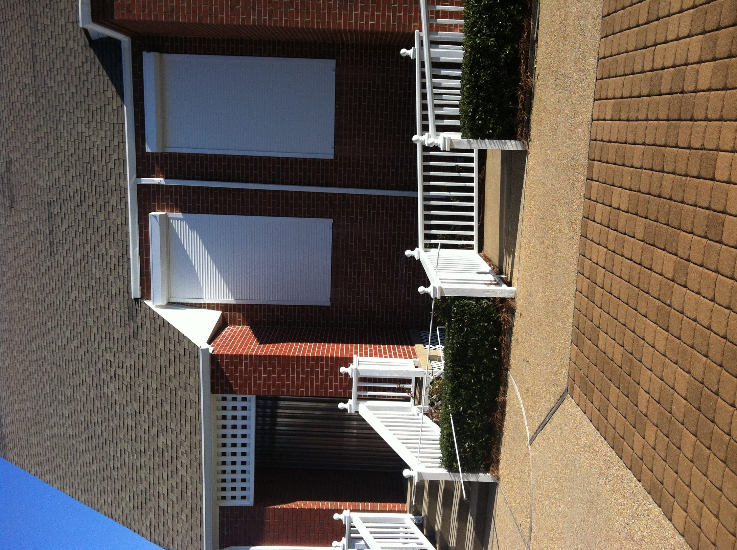 Coastal brick community building with white hurricane shutters.