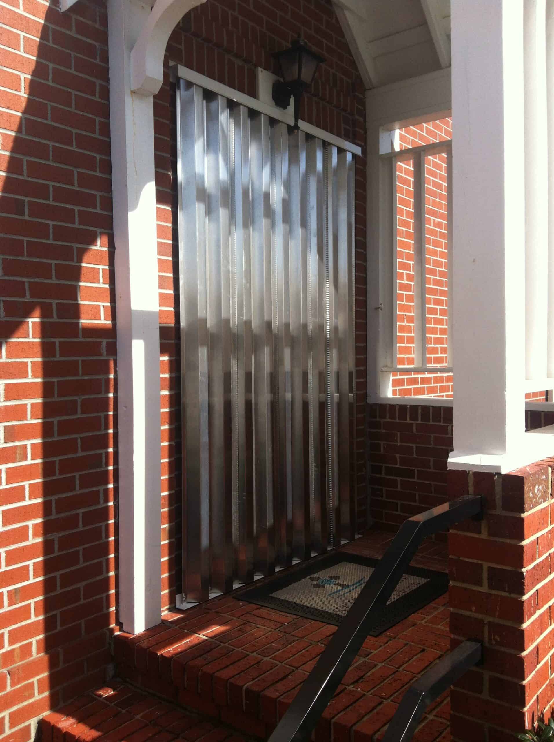 Aluminum hurricane panels protecting sliding glass doors on a Carolina beach house