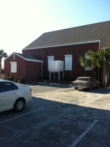 Wilmington two-story brick building, white hurricane shutters.
