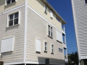 Yellow coastal apartments with white hurricane shutters.