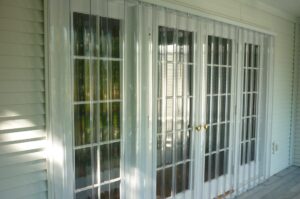 Wilmington clear accordion hurricane shutters protect French doors.