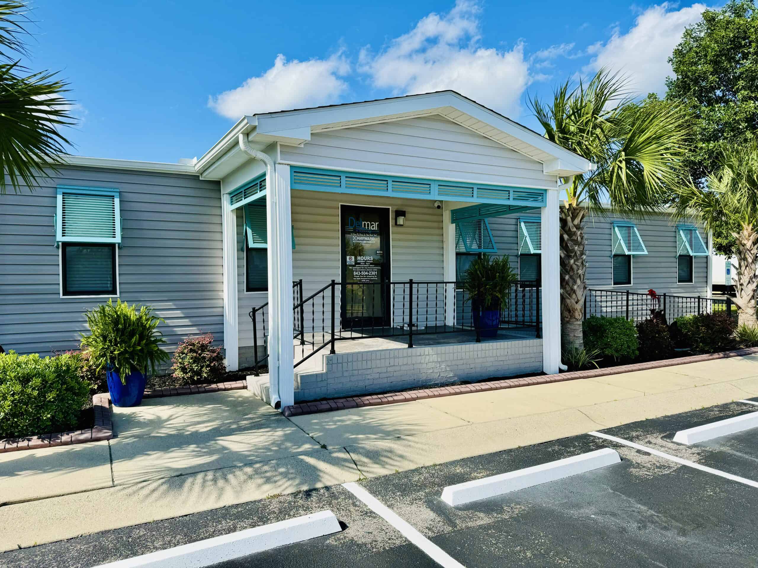 Bahama hurricane shutters on a light blue coastal home showing color-matched installation