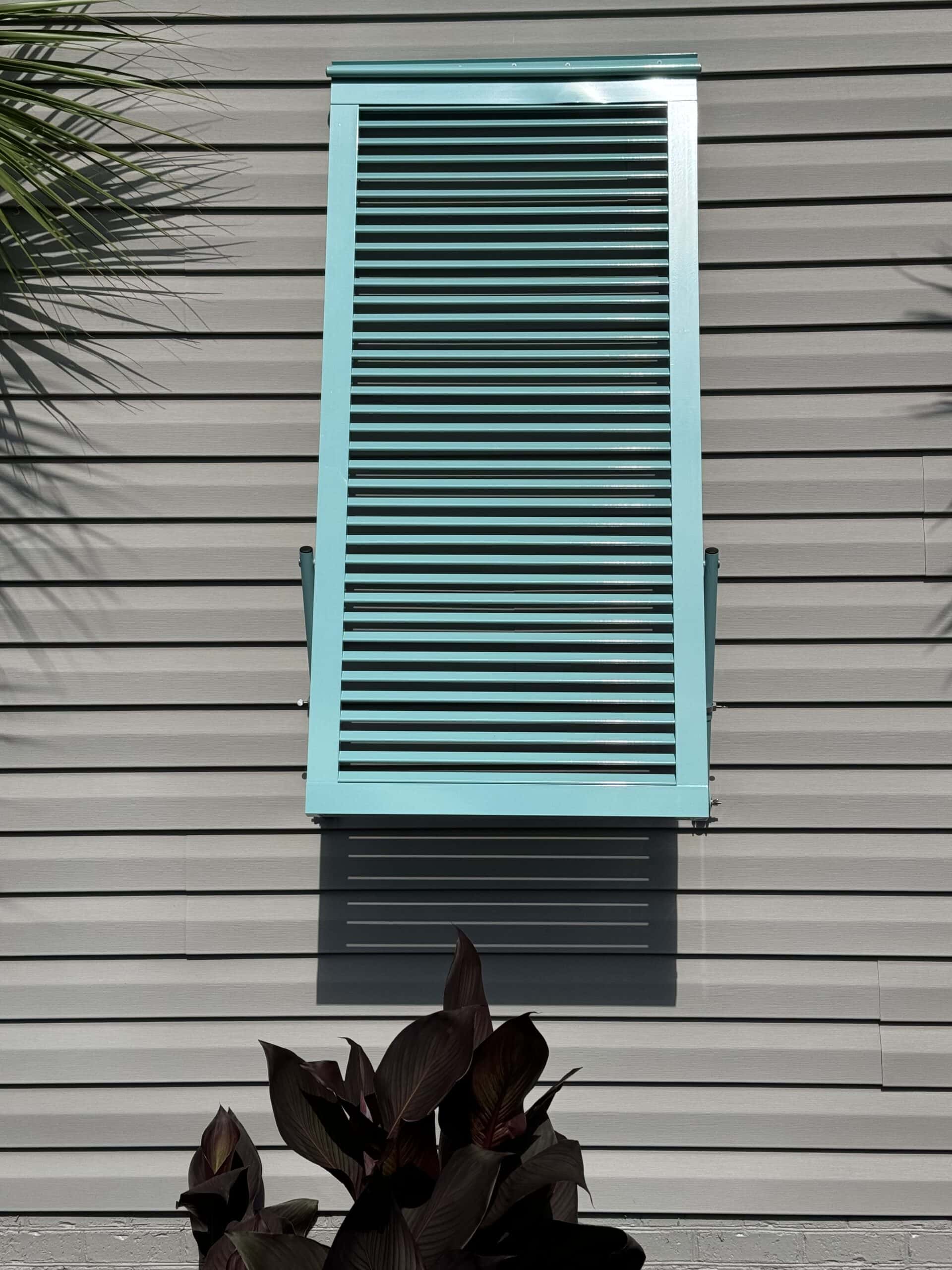 Bahama hurricane shutters installed above windows on a Carolina Beach home