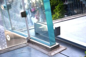 Modern laminated glass railing with brushed metal fittings.