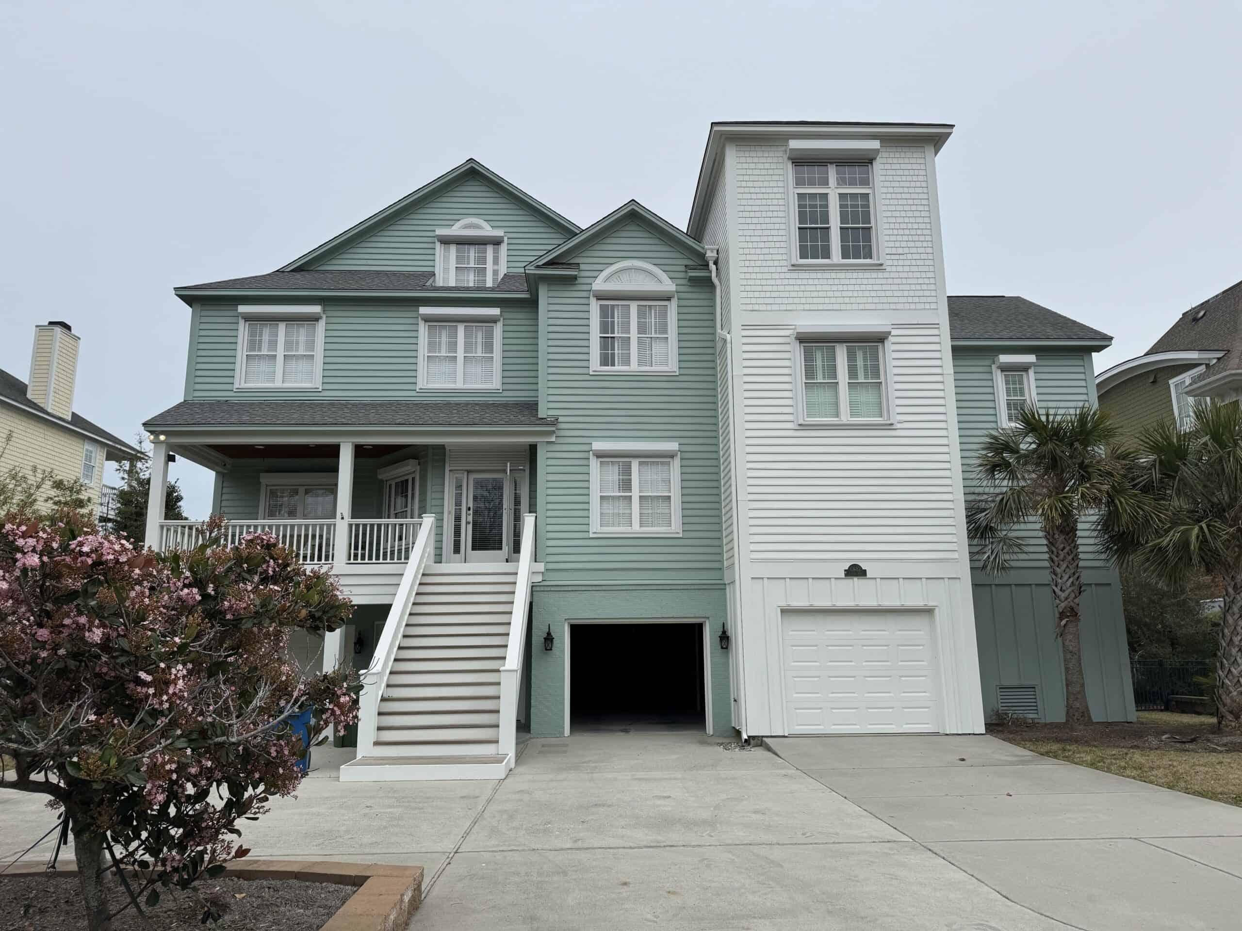 Teal coastal home with rolldown hurricane shutters installed on all windows
