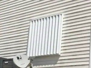 Wilmington white home, vertical hurricane shutters, DIRECTV dish.