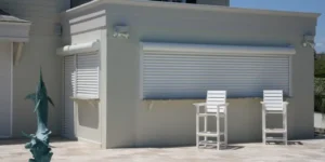 Modern coastal outdoor bar with hurricane shutters and marlin sculpture.