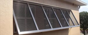 Aluminum louvered sun and storm shutters for coastal homes.
