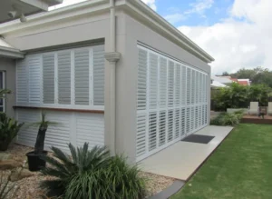 Modern Wilmington home exterior with white louvered hurricane shutters.