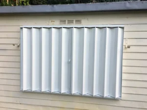 Accordion hurricane shutters secure coastal home window.