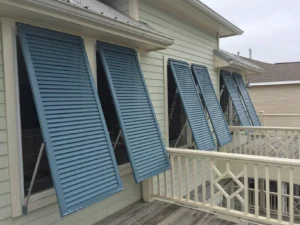 Topsail beach house, open blue-green louvered hurricane shutters.