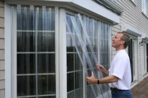 Myrtle Beach man installing clear Lexan hurricane panels.