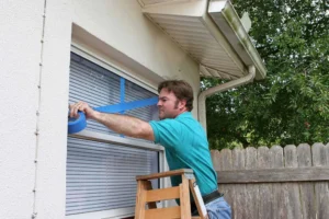 Man taping window for hurricane protection in Wilmington.