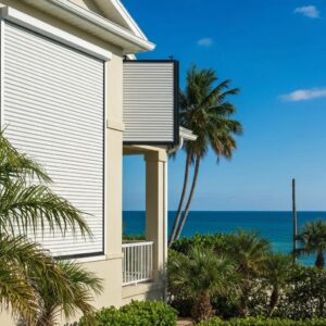 Coastal home with accordion hurricane shutters showcasing storm protection and ocean view