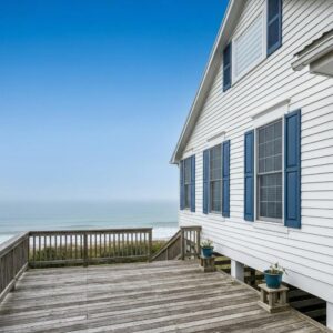 Coastal home with hurricane protection features in North Carolina, showcasing shutters and elevated foundations