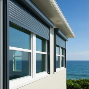Coastal home with roll-down hurricane shutters partially open, emphasizing storm protection and design