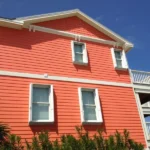 White accordion hurricane shutters on an orange home in North Myrtle Beach SC.
