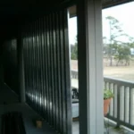 Corrugated aluminum storm panels stacked and ready for deployment on a Holden Beach rental.