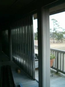 Corrugated aluminum storm panels stacked and ready for deployment on a Holden Beach rental.