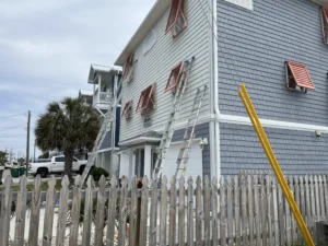 Decorative Bahama storm shutters providing shade on a historic home in Southport NC.